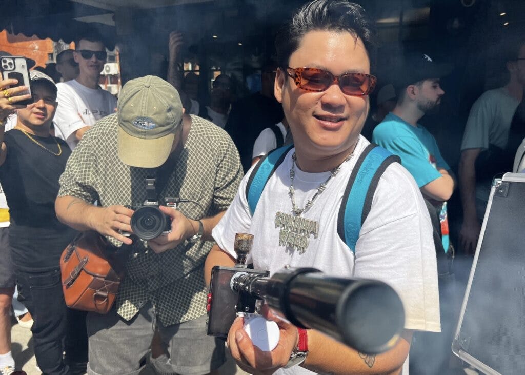 Man holds smoke gun at Cookies Cannabis opening. The smoke gun that helped customers get high while they waited in line. (Mikhail Harrison / Leafly)
